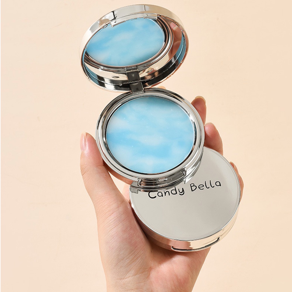 The compact held in one hand to show its size
